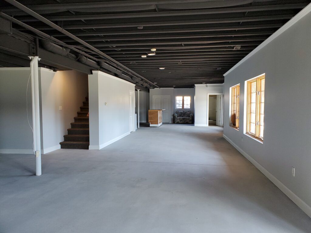 A large empty room with stairs and windows