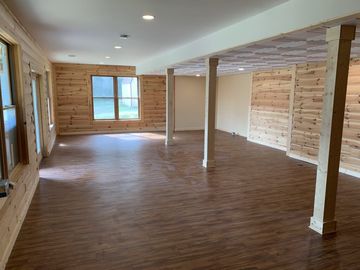 A large empty room with wooden walls and hardwood floors.