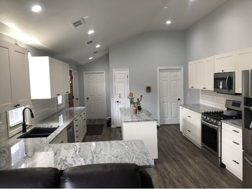 A kitchen with white cabinets and stainless steel appliances