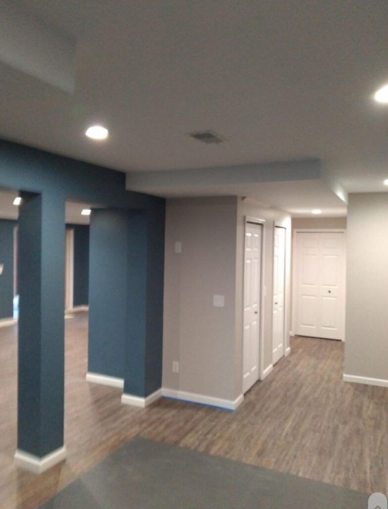 A basement with blue walls and wood floors