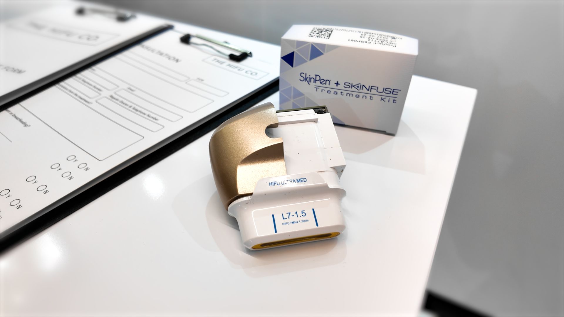 A device is sitting on a table next to a box and a clipboard.