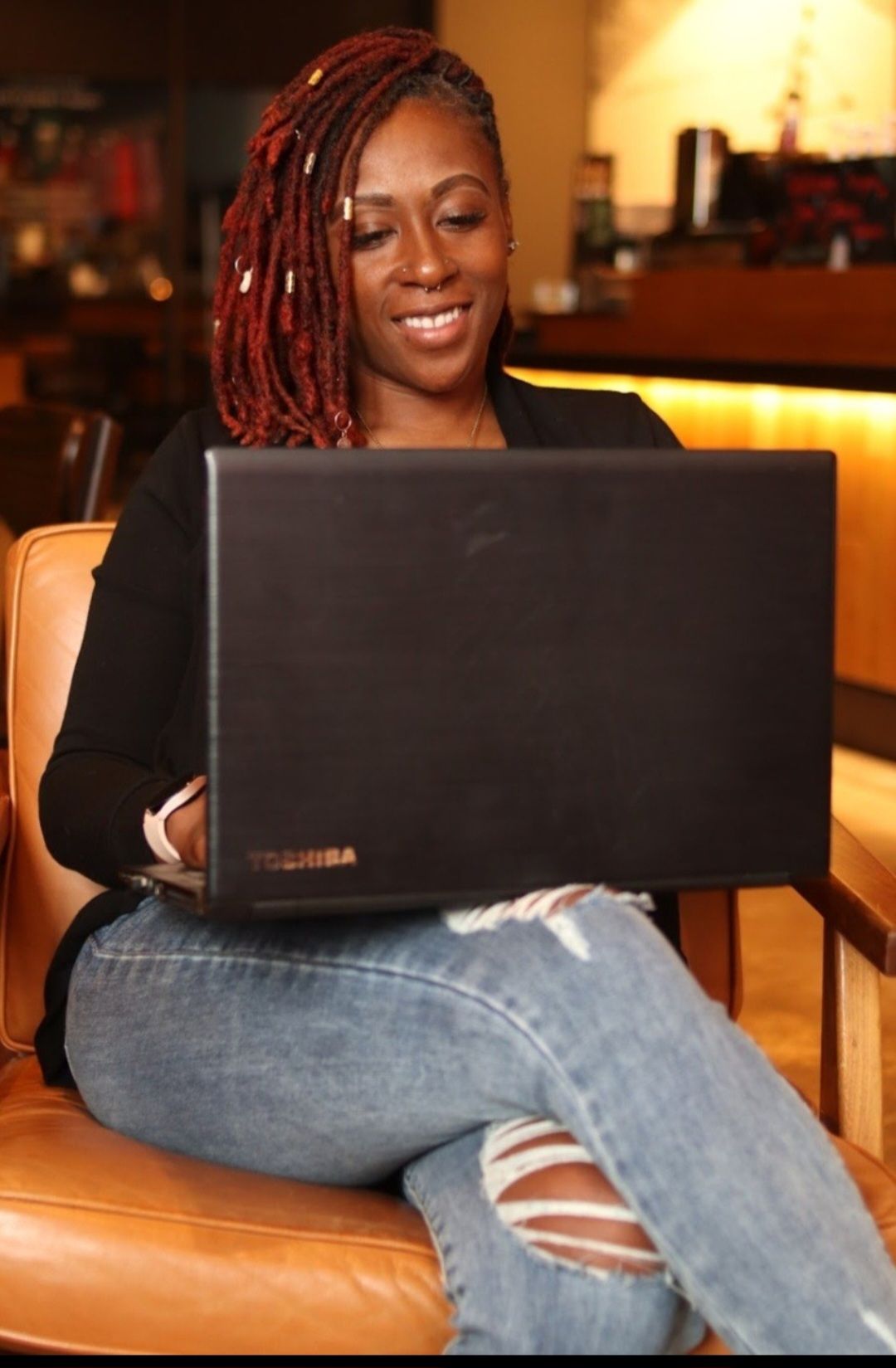 Alexandrea Long, LCSW-S using laptop representing someone researching complex PTSD resources and connecting with trauma-informed therapy support