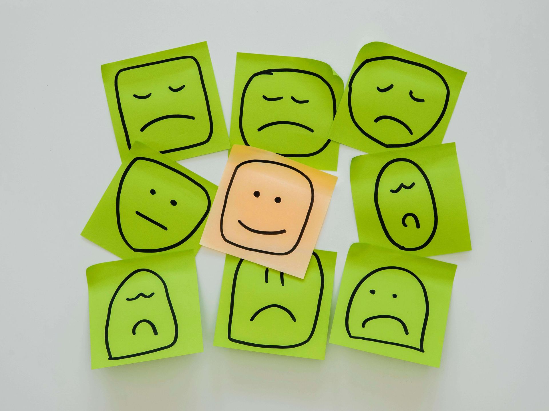Colorful sticky notes with sad and happy emotional faces representing trauma triggers and healing