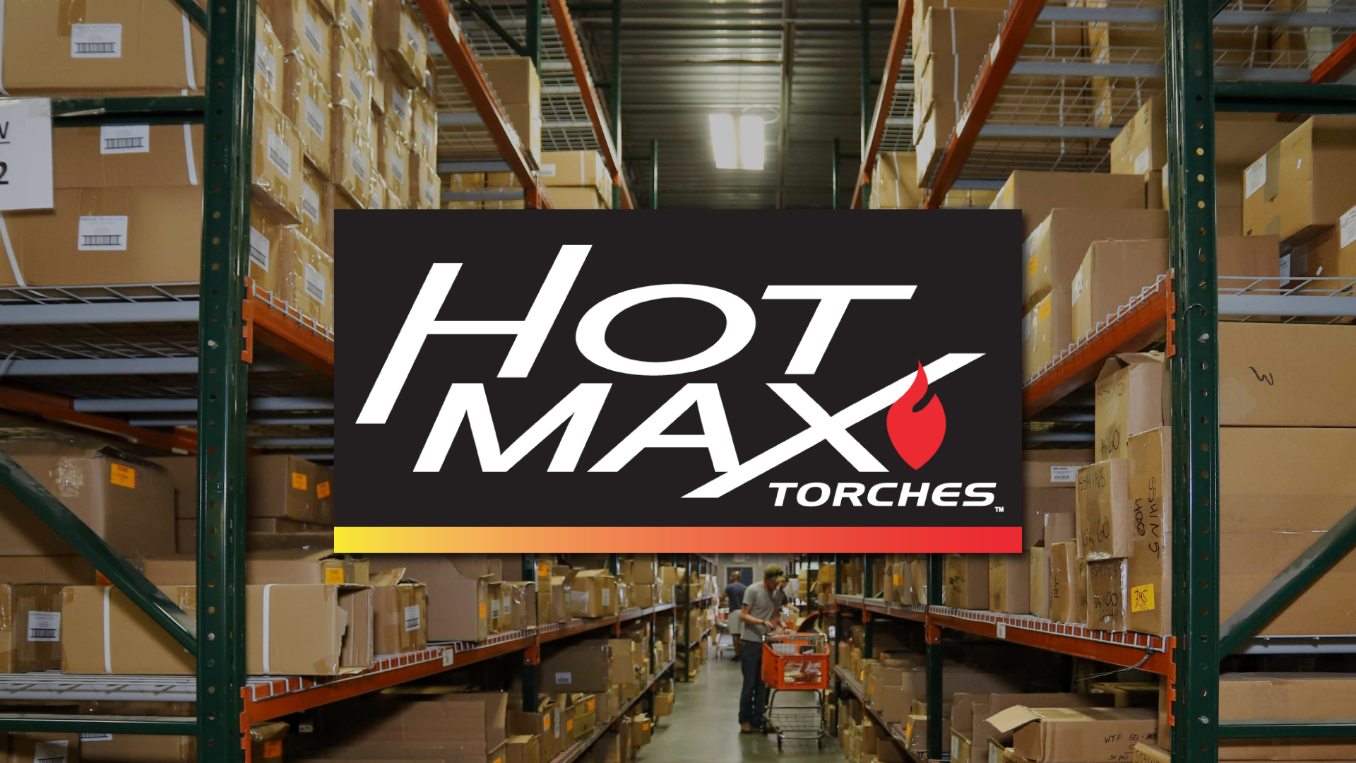 A Hot Max Torches logo is overlaid on a warehouse aisle filled with stacked cardboard boxes on metal shelves.