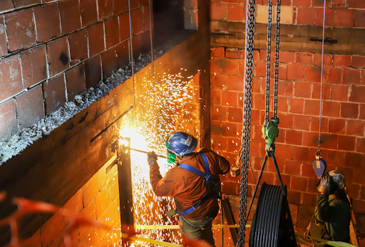 A welder working in an elevator shaft