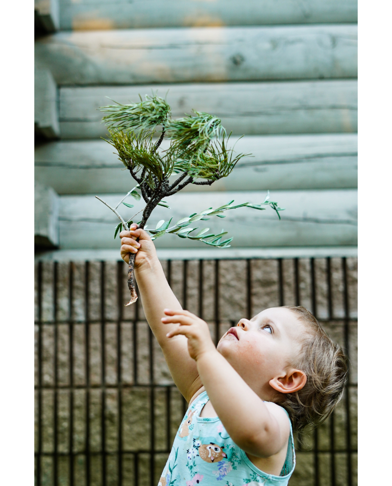 A profile view of a toddler reaching up.