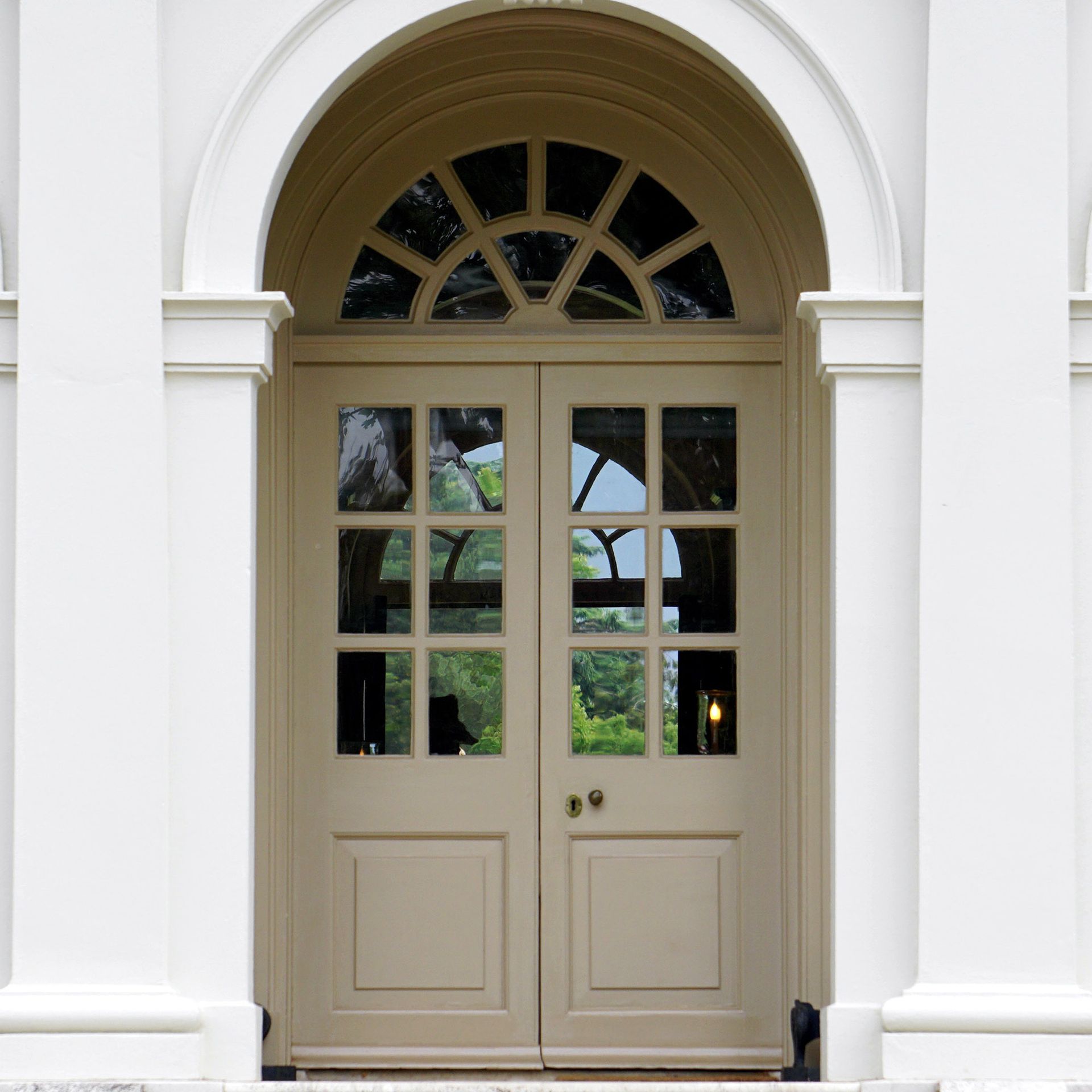 the front door of a white building with arched windows