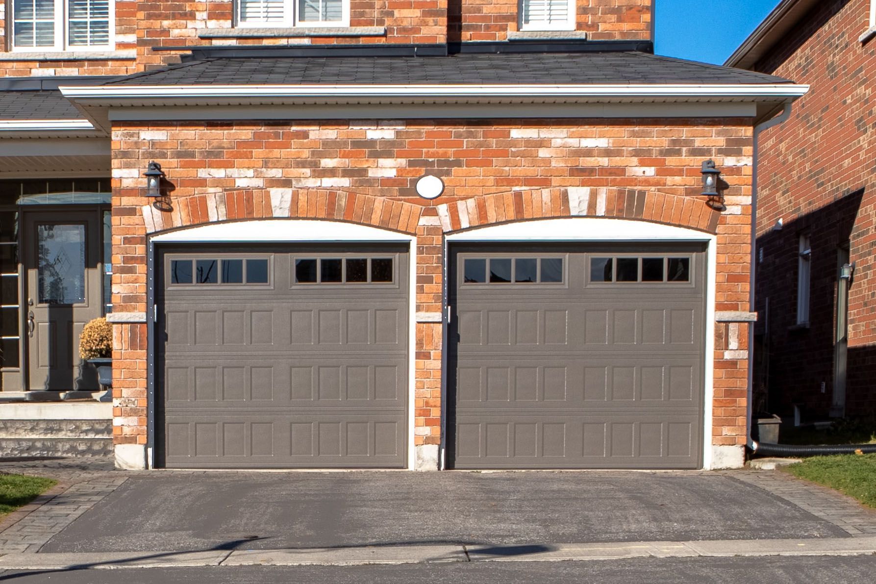 a brick house with two garage doors in front of it