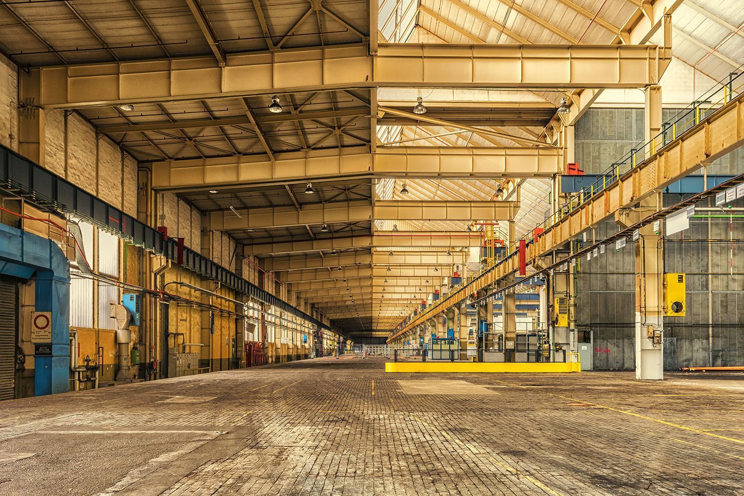 a large empty warehouse with a lot of machinery in it .