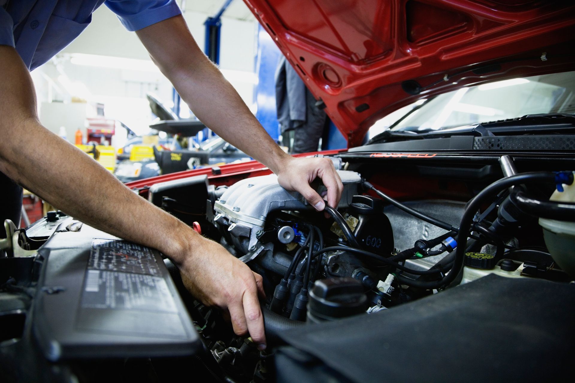 A man repairs a car engine in an auto repair shop in Villa Park Village.
