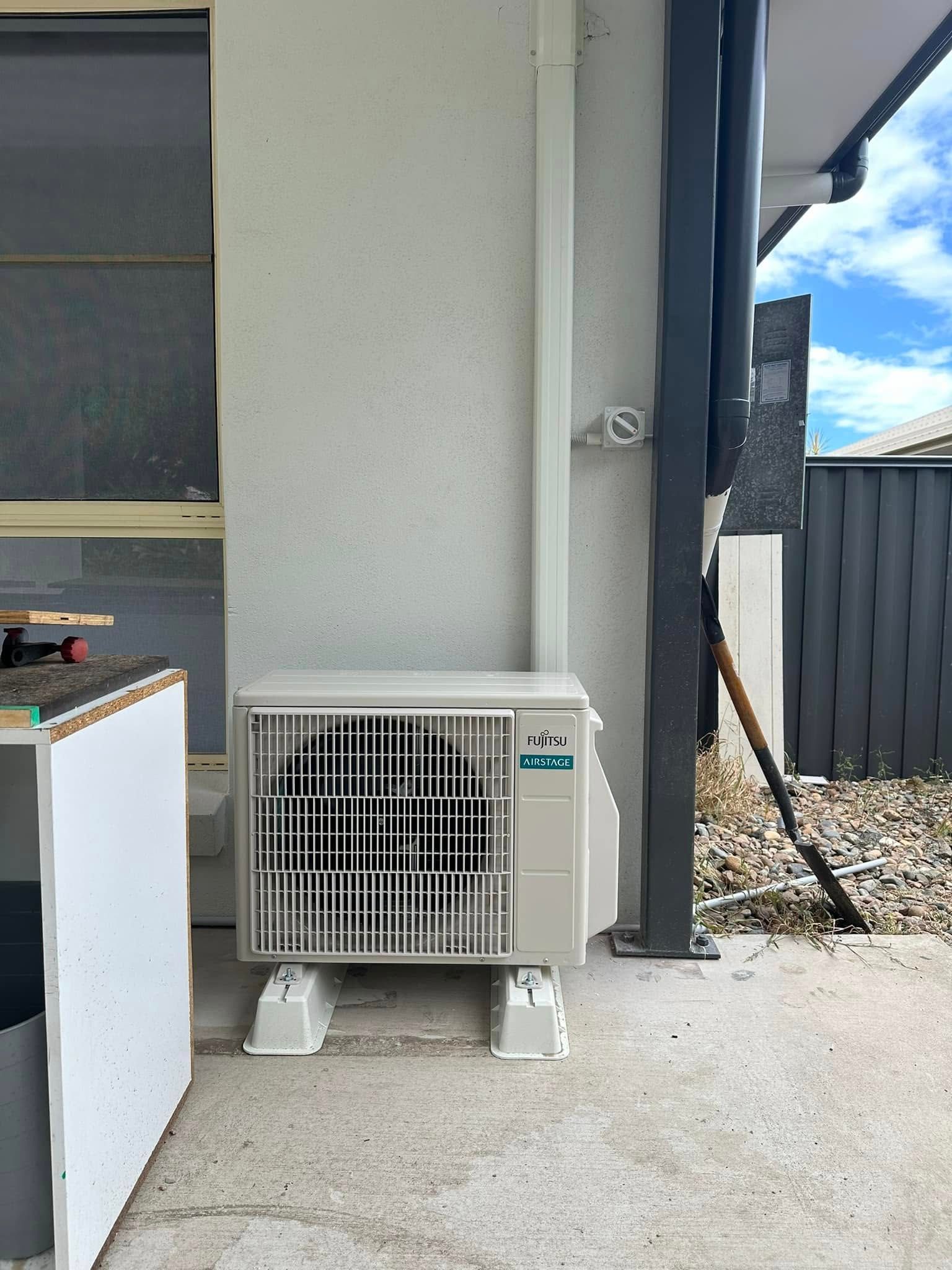 Air Conditioner Unit Sits on a Concrete Patio — DJL Refrigeration & Air Conditioning In Bowen, QLD