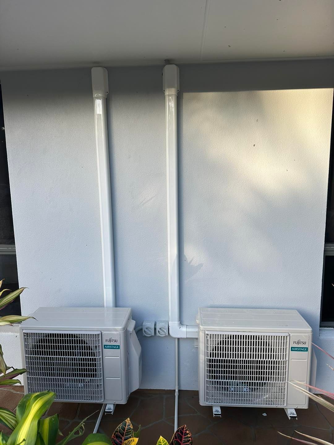 Two White Air Conditioning Units Mounted on a Wall — DJL Refrigeration & Air Conditioning In Cannonvale, QLD