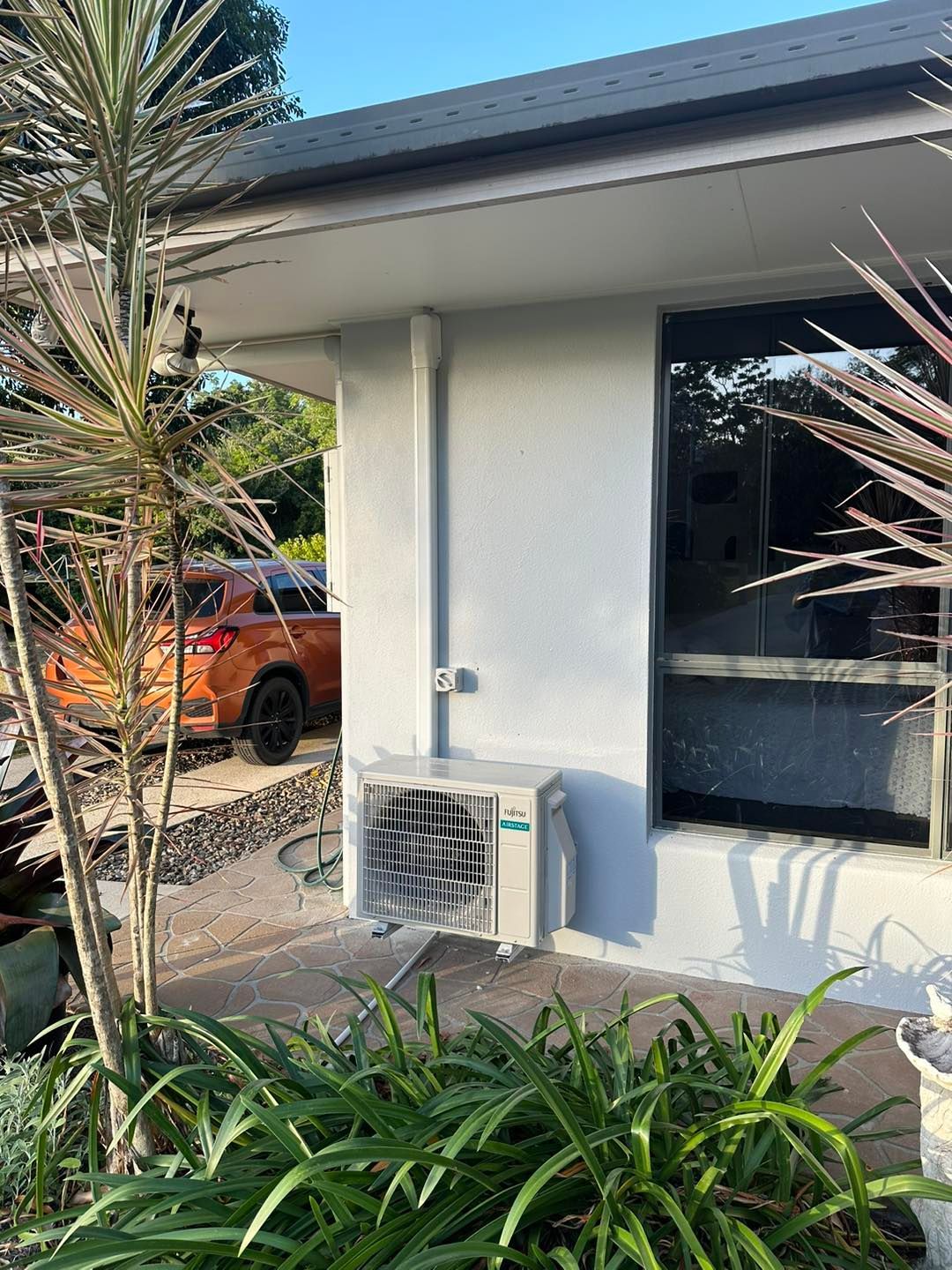 Exterior of a Light Gray House With an Air Conditioning Unit — DJL Refrigeration & Air Conditioning In Cannonvale, QLD