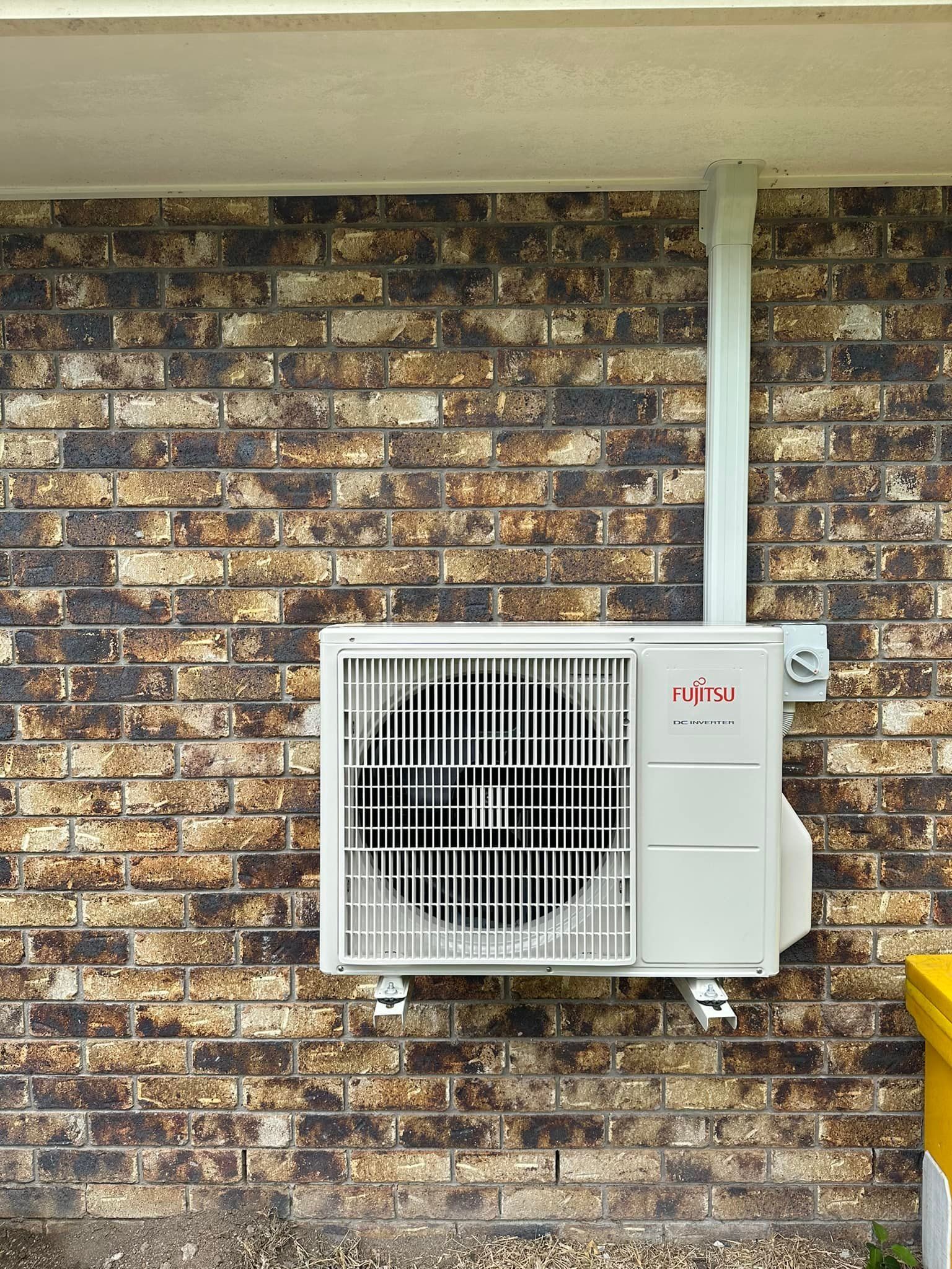 Air Conditioning Unit Mounted on a Brick Wall — DJL Refrigeration & Air Conditioning In Cannonvale, QLD