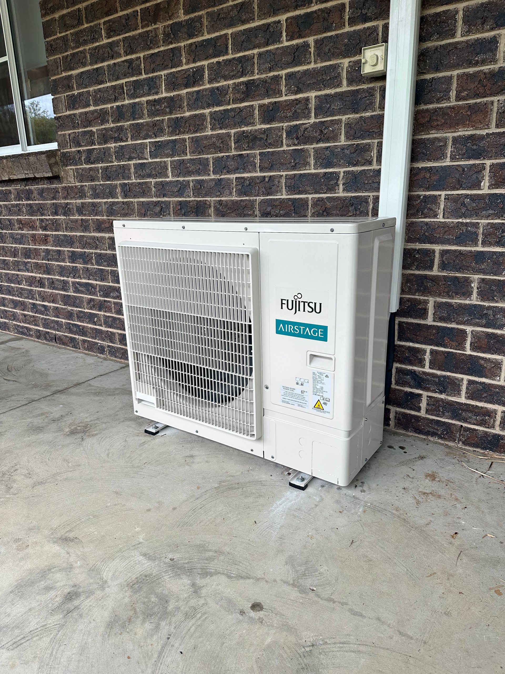 Fujitsu Air Conditioning Unit Mounted on a Brick Wall — DJL Refrigeration & Air Conditioning In Cannonvale, QLD
