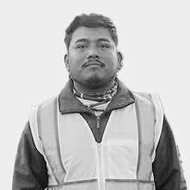 A black and white photo of a man wearing a safety vest.