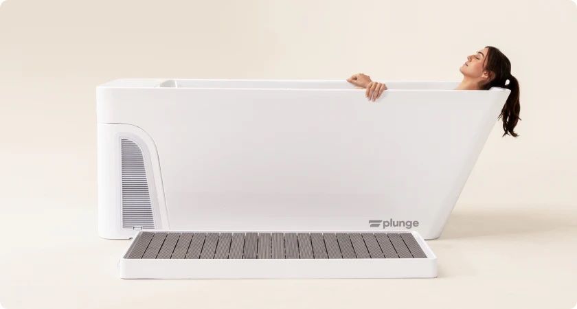 A woman is taking a bath in a white bathtub