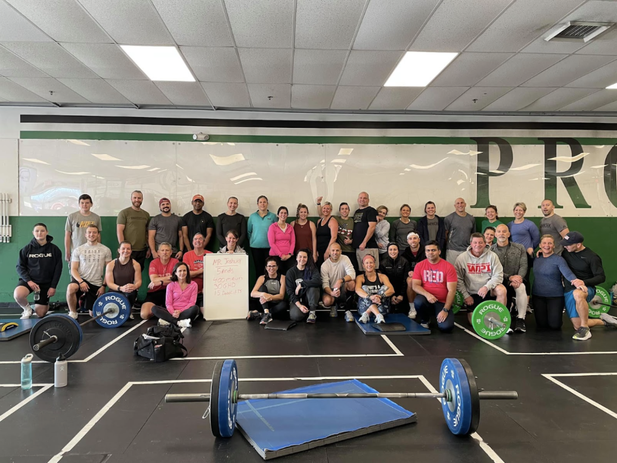 A group of people are posing for a picture in a gym.