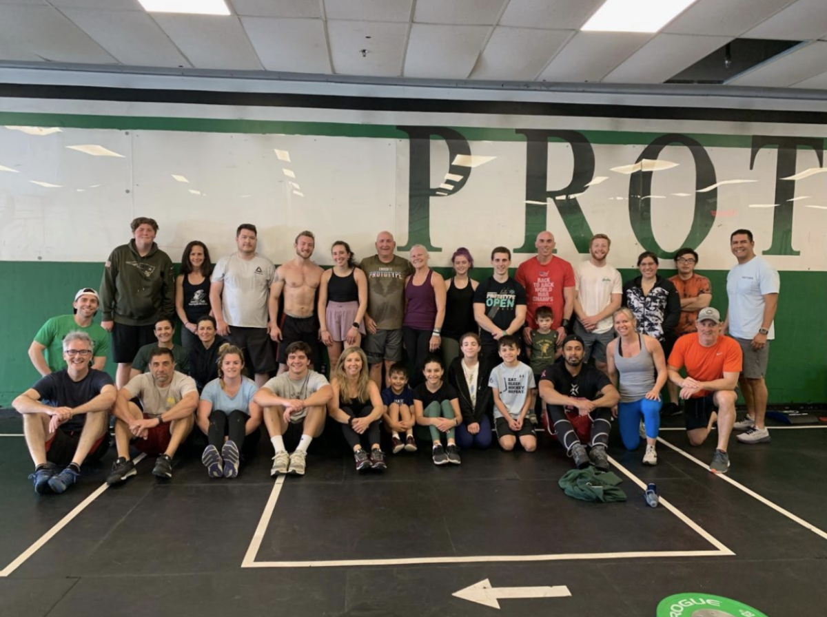 A group of people posing for a picture in front of a wall that says prot