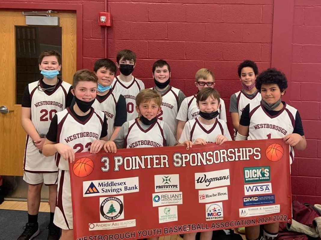 A group of young boys are holding a sign that says `` 3 pointer sponsorships ''.