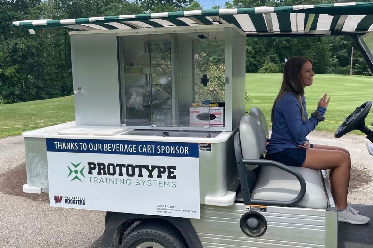 A woman is sitting in a golf cart on a golf course.