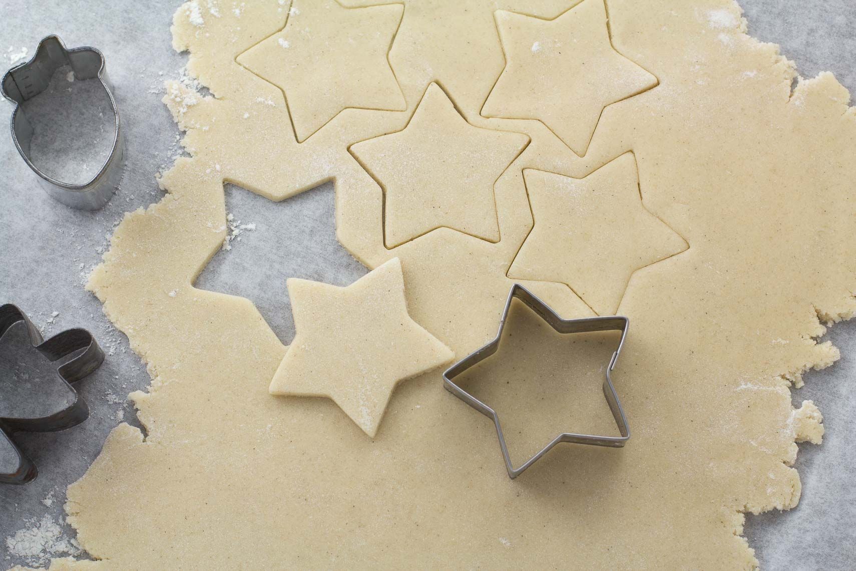 A piece of dough with star shaped cookie cutters on it.