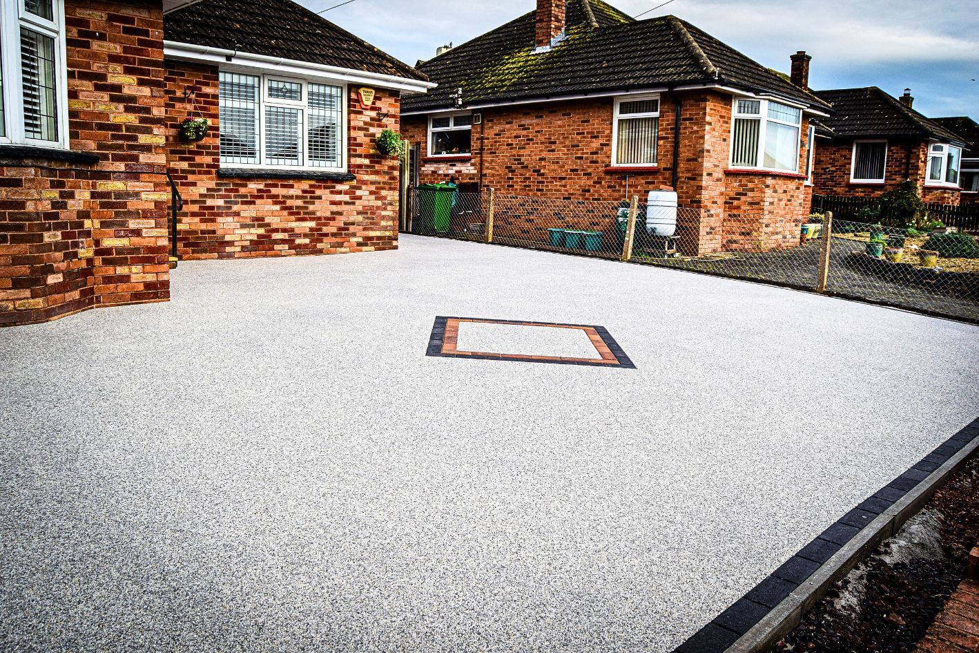 Image of a grey resin driveway, from the side.