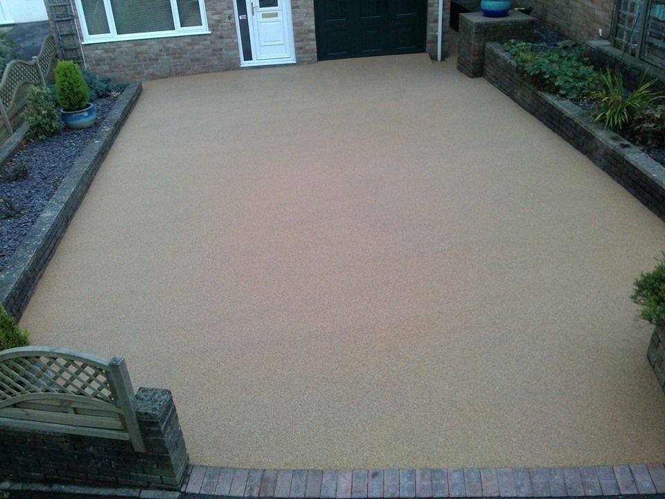 A resin bound driveway with red blocks to finish the top of the drive.