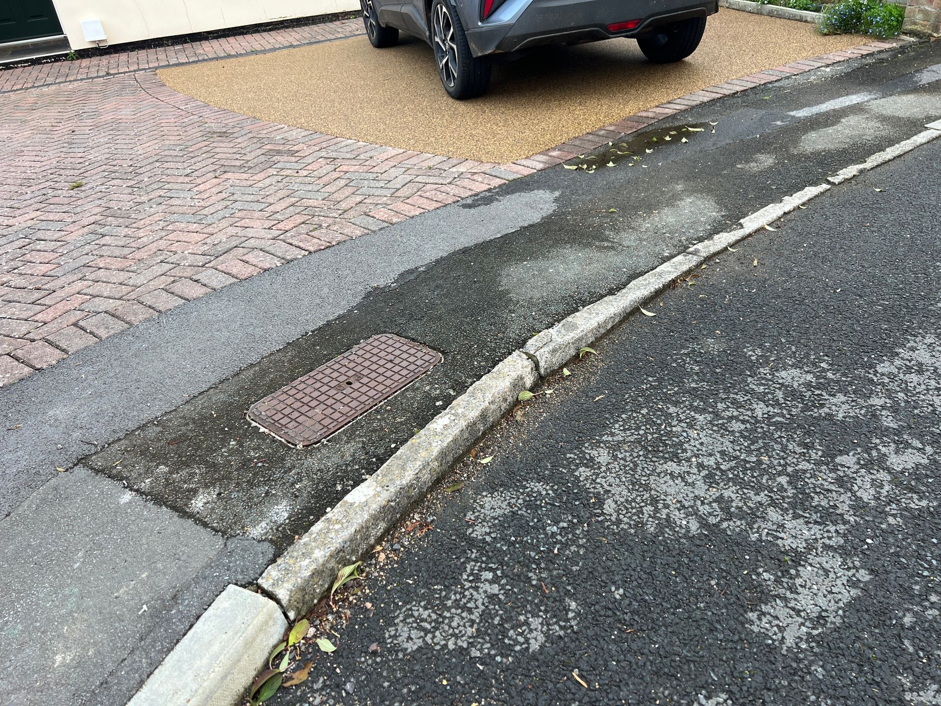 A resin bound driveway with red blocks to finish the top of the drive.