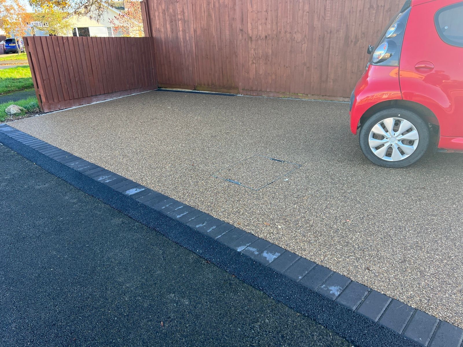 Completed resin driveway project in Bristol, with a red car parked on it.