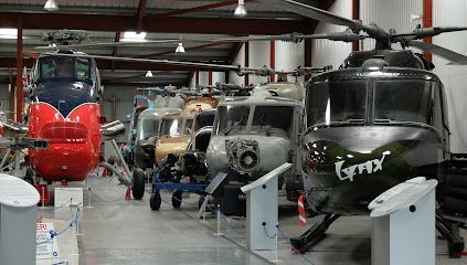 Helicopters in a hangar; diverse colors and models on display, angled from right to left.