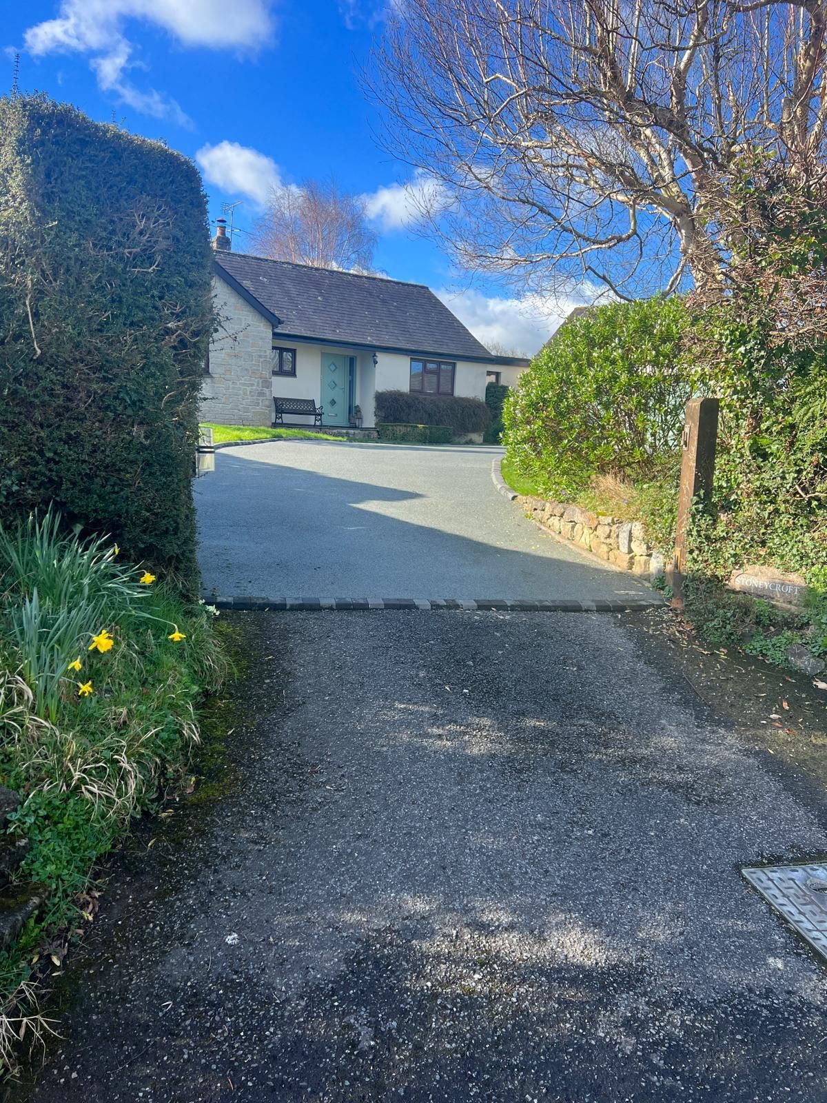 A driveway leading to a house on a sunny day.