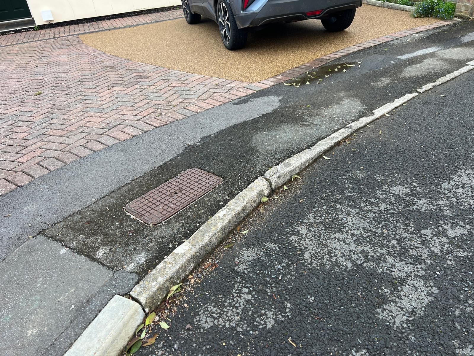 A car is parked on the side of the road next to a curb.