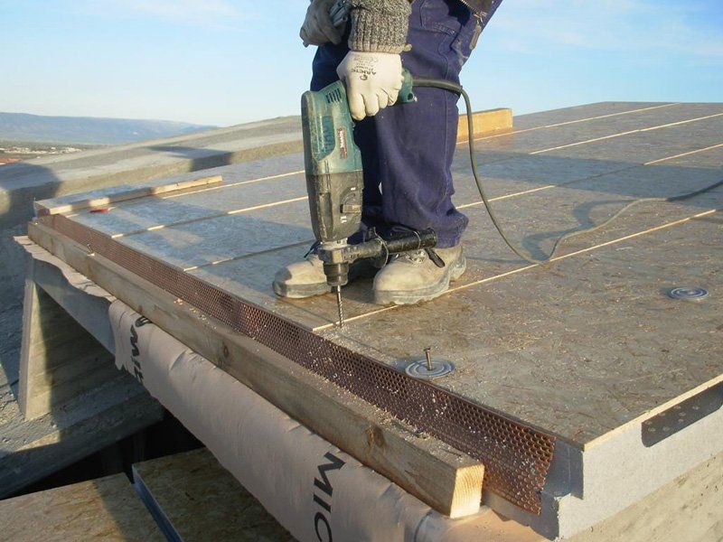 operaio mentre riparazione il tetto con una macchina di trapano