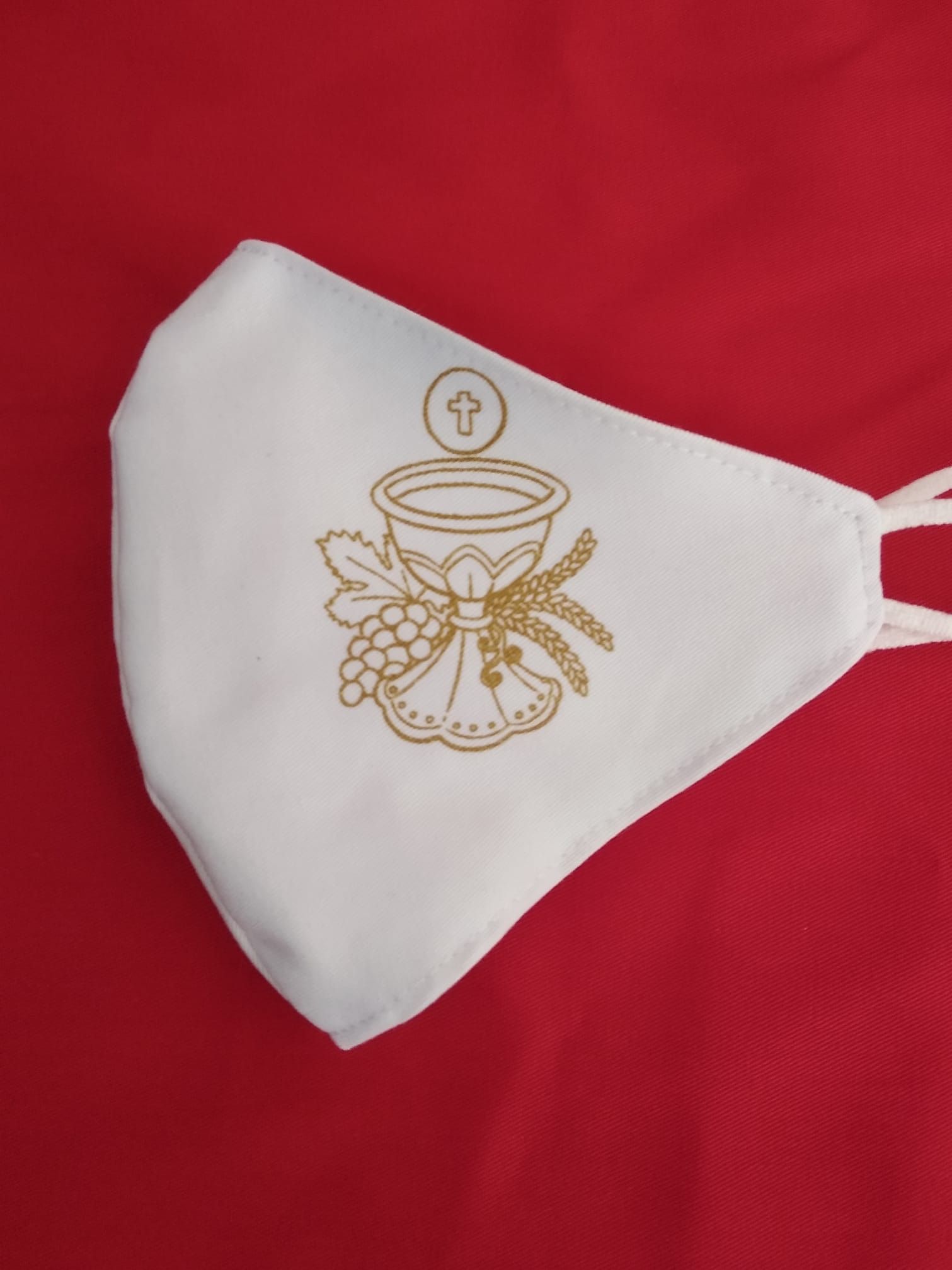 Una maschera bianca con un calice e dell'uva sopra