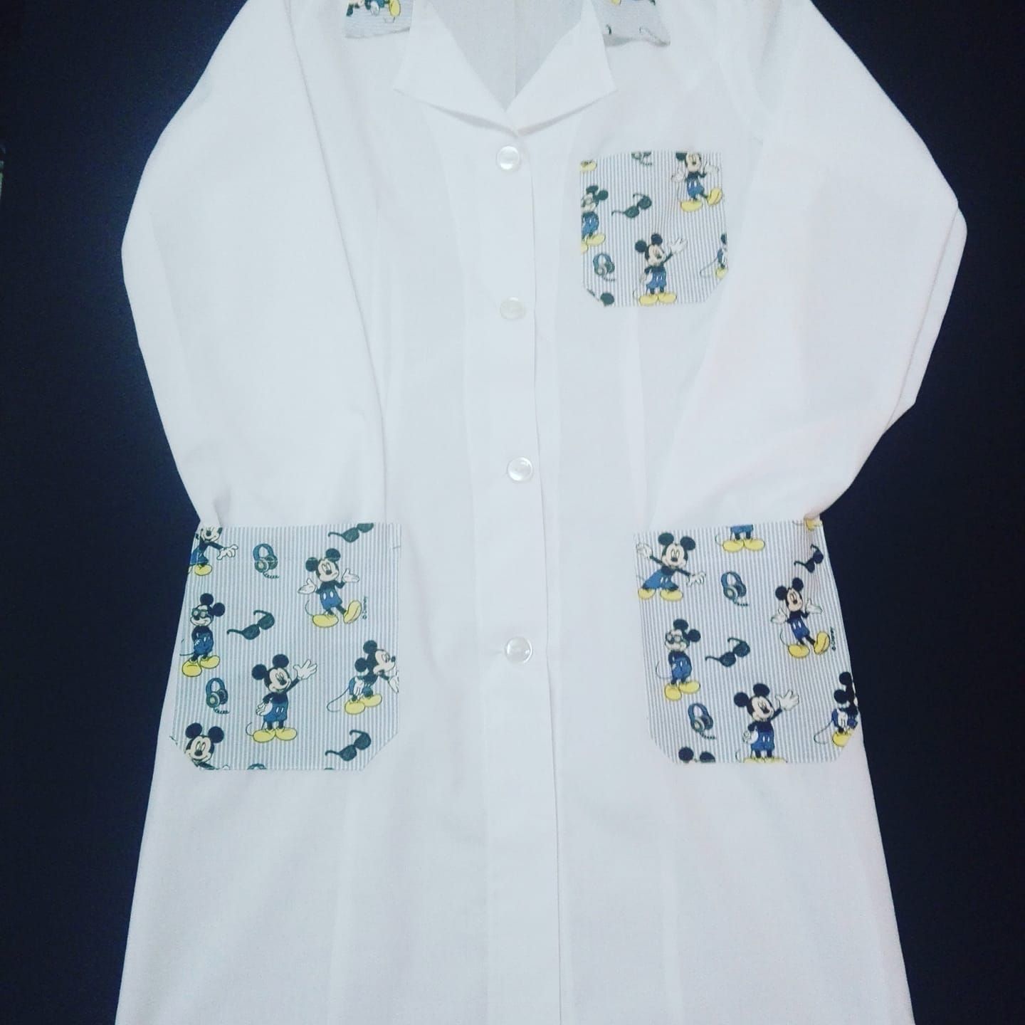 Un camice bianco con Topolino sulle tasche