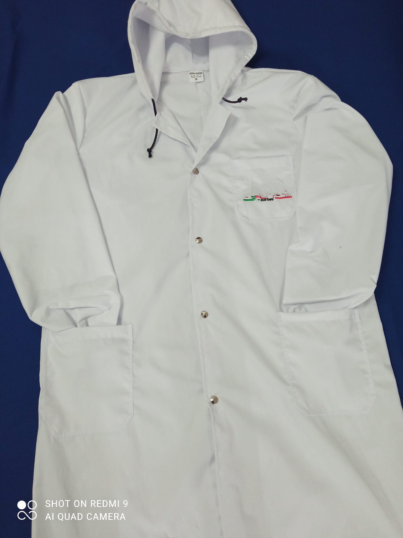 Un camice bianco con cappuccio su sfondo blu