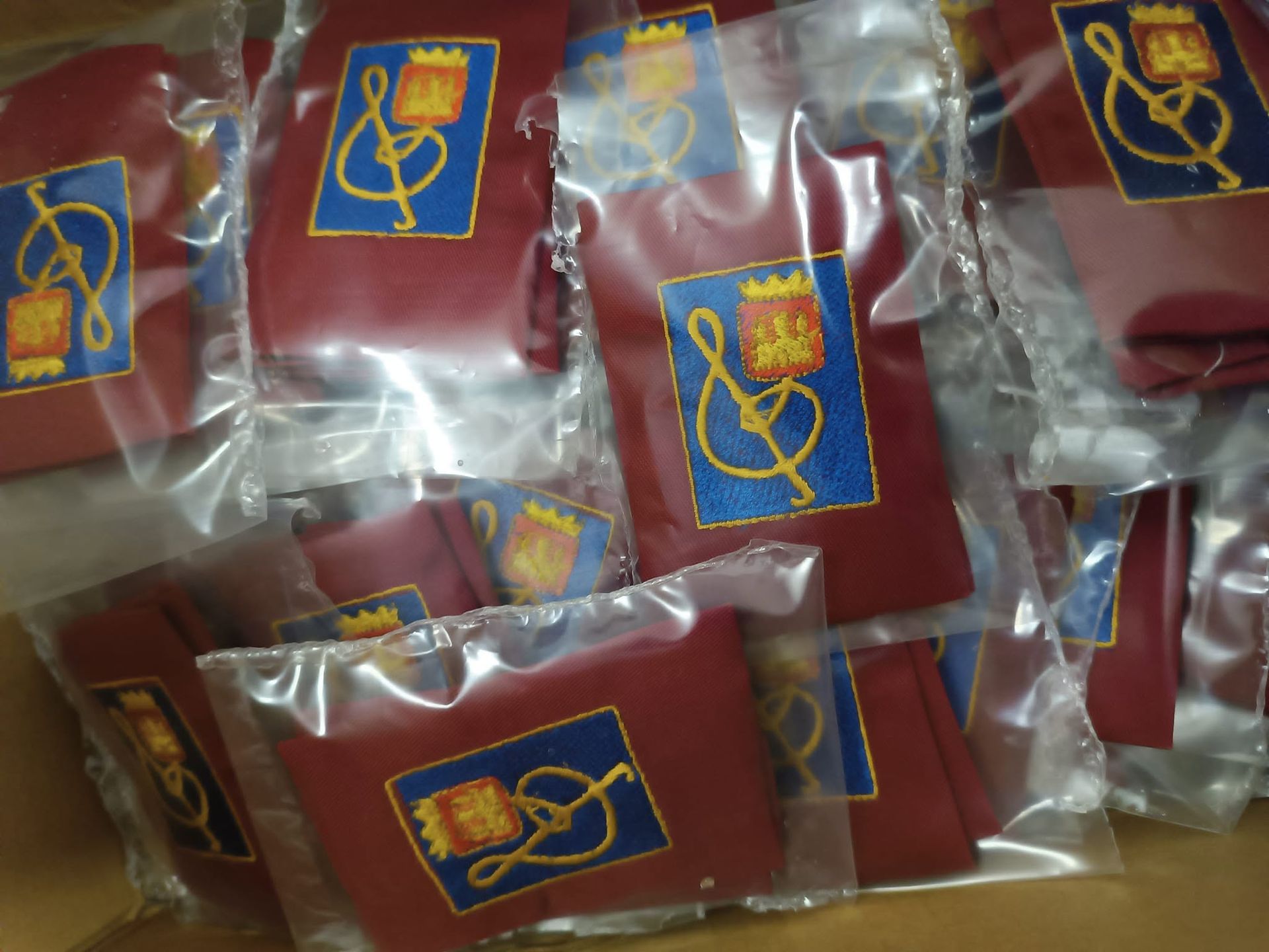 Un mucchio di borse rosse con loghi blu e gialli sopra