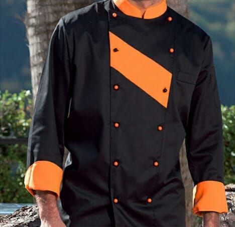 Un uomo che indossa una giacca da cuoco nera e arancione