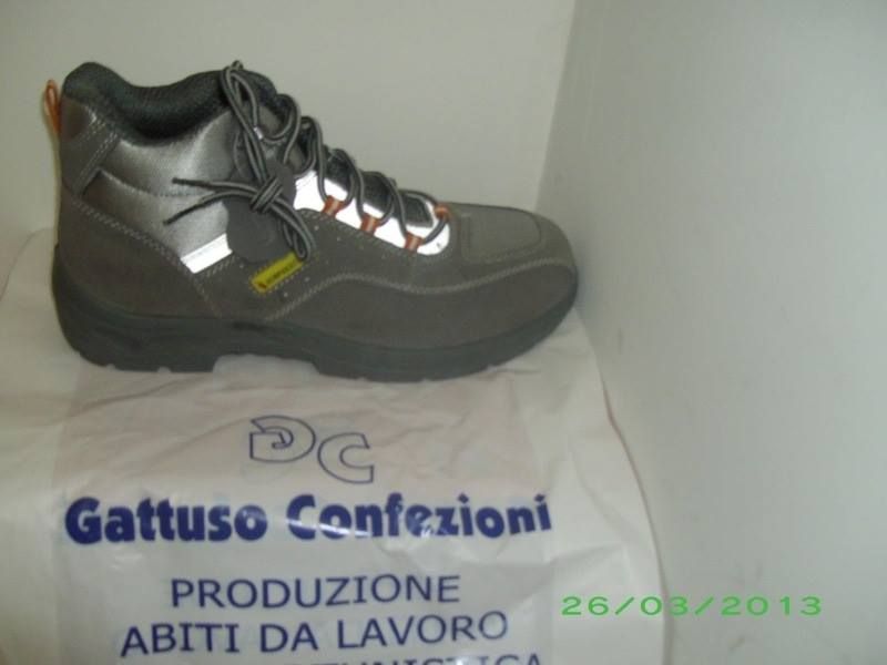 Un paio di stivali poggia su una borsa con la scritta Gattuso Confezioni