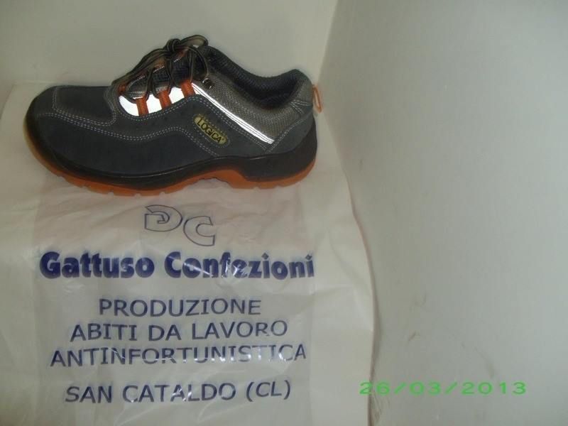 Un paio di scarpe antinfortunistiche sono appoggiate su una borsa con la scritta Gattuso Calzature