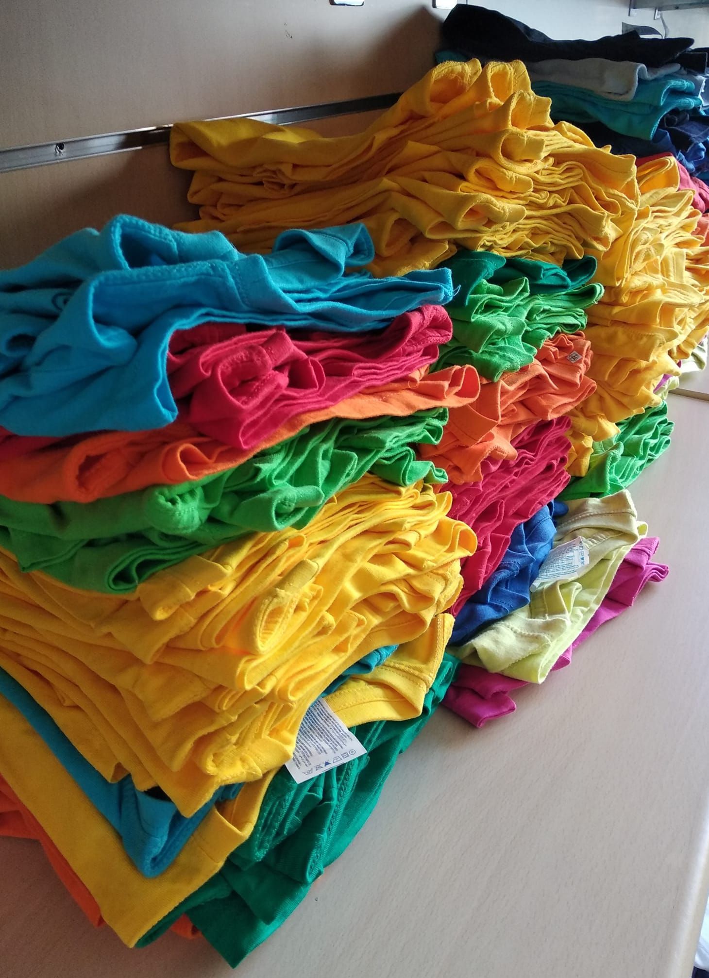 Un mucchio di vestiti colorati sono impilati uno sopra l'altro