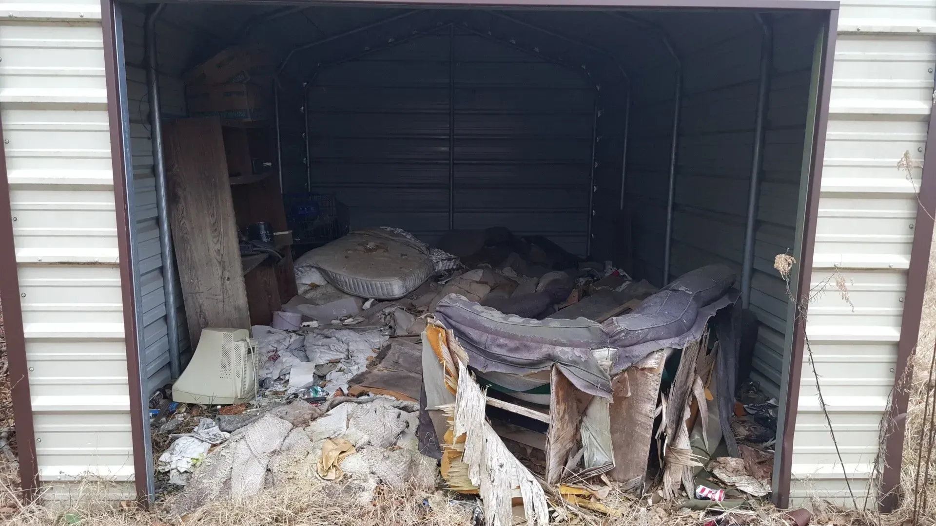 A garage filled with lots of trash and junk.