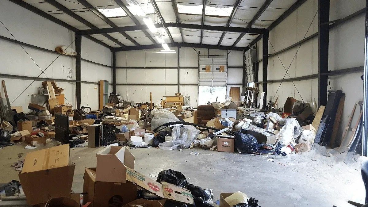 A large warehouse filled with lots of trash and boxes.