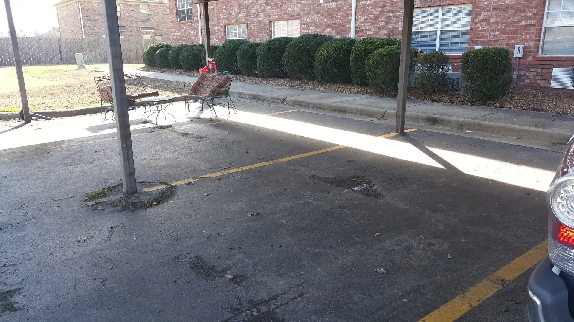 A car is parked in a parking lot in front of a brick building.