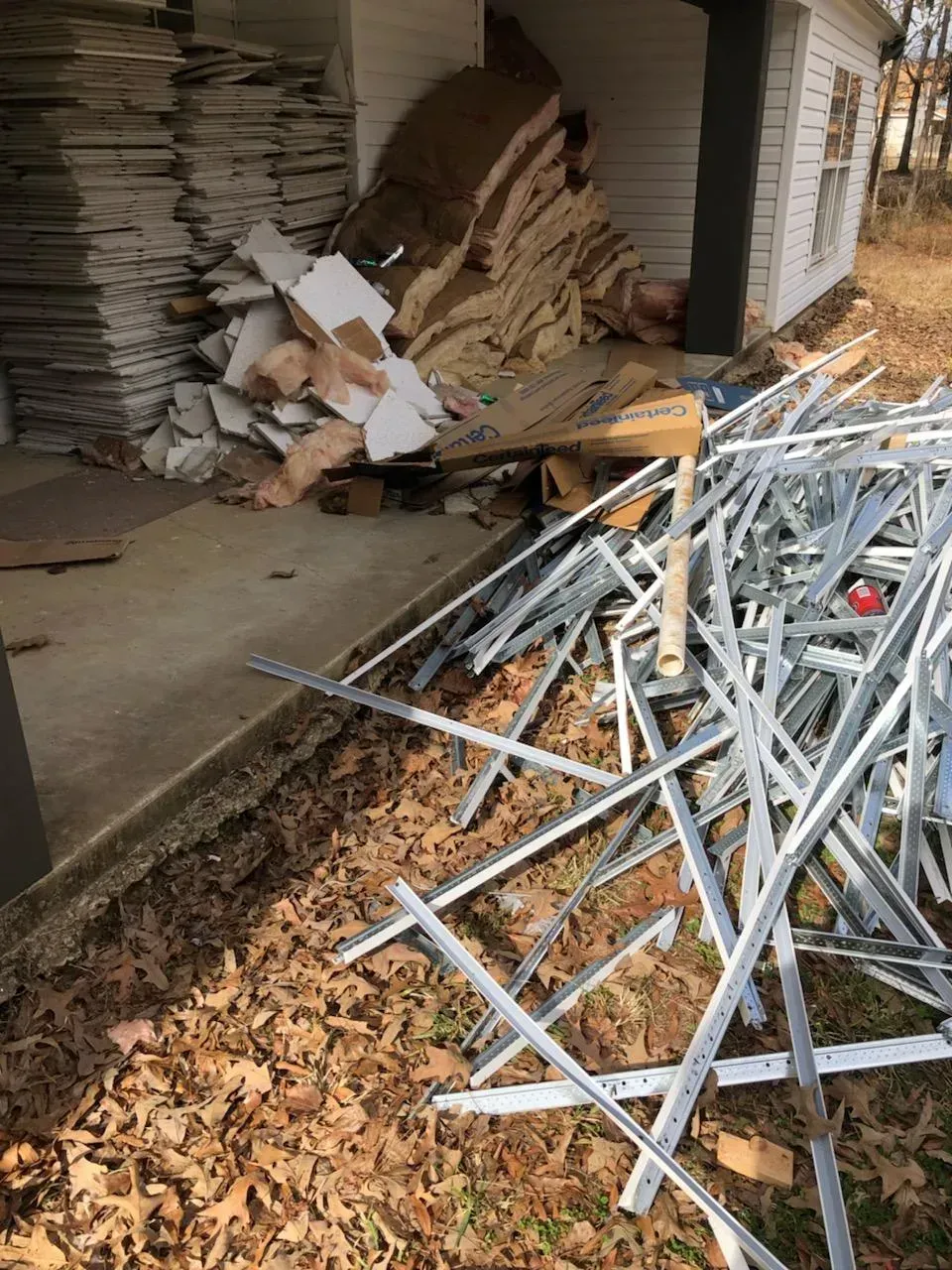 A pile of metal is sitting on the ground in front of a house.