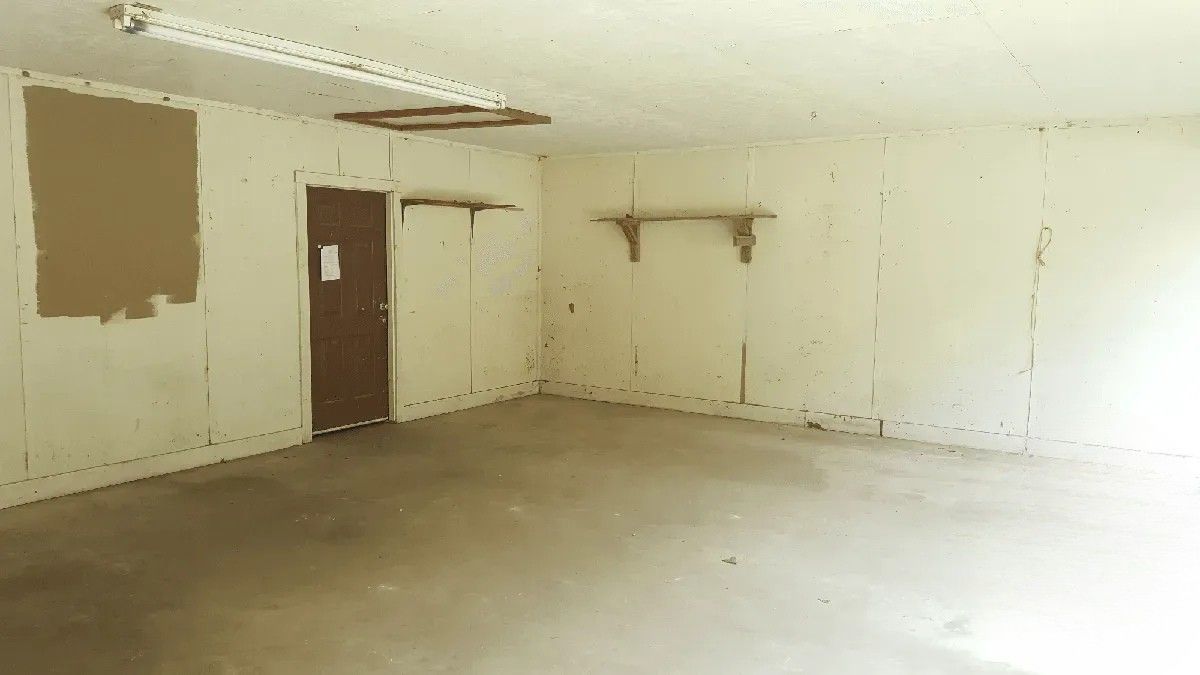 An empty room with a door and shelves in it.