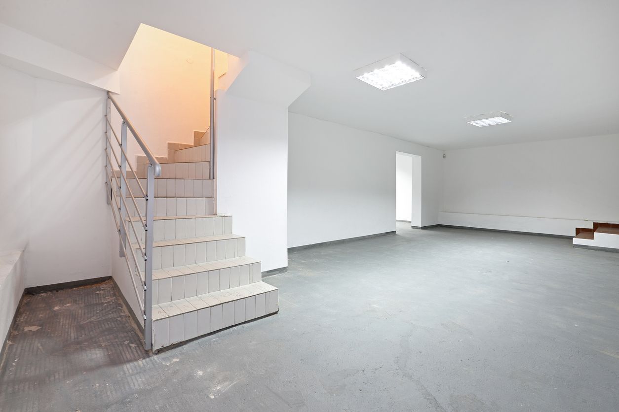 An empty basement with stairs leading up to the second floor.