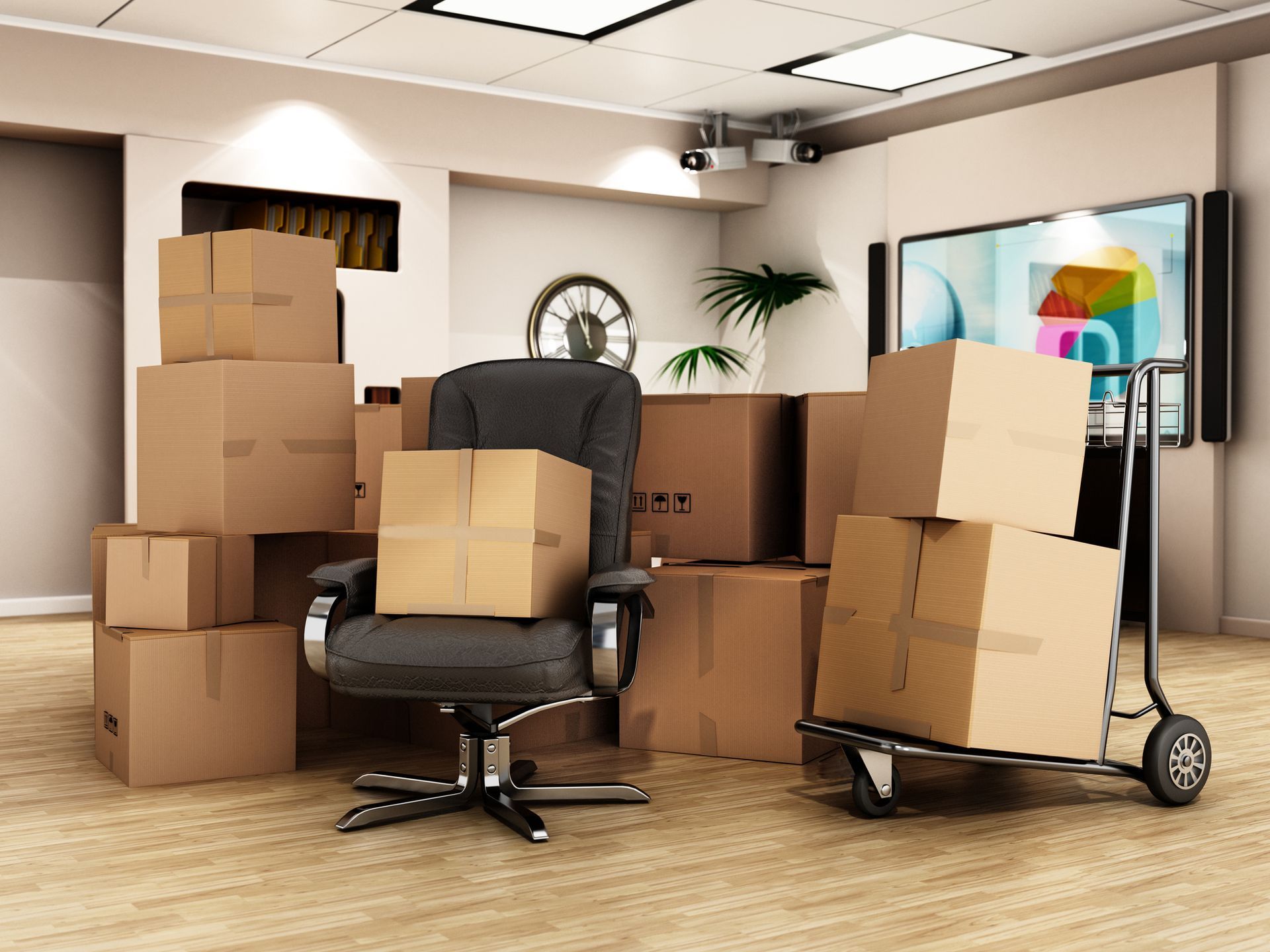 Office being packed up: cardboard boxes piled around a chair, some on a hand truck.