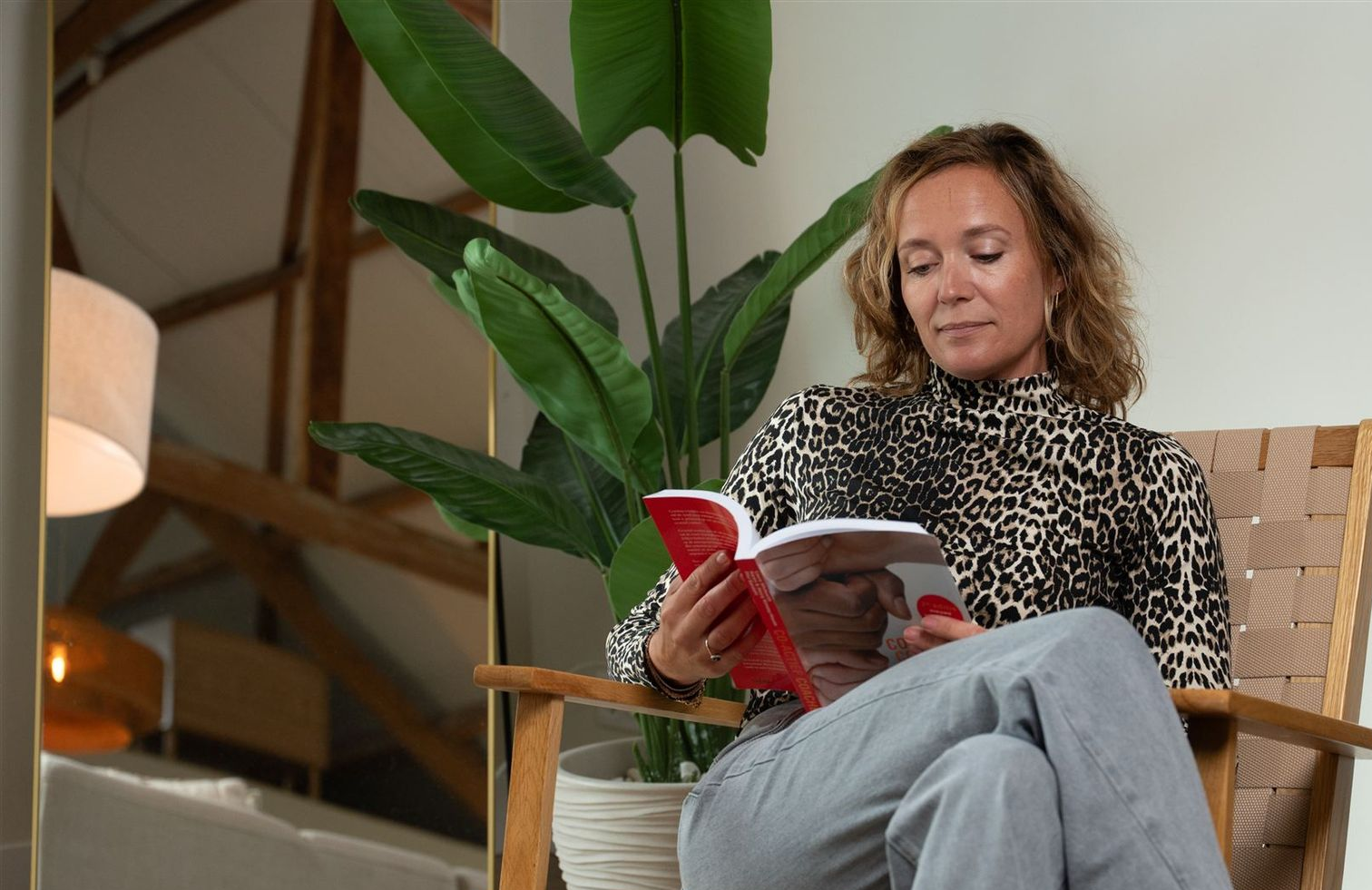 Zittend op stoel een boek lezend, symbool voor kennis en persoonlijke ontwikkeling
